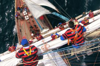 Sail trainees climbing the mast on tall ship Pogoria.